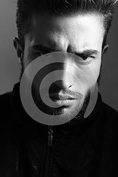 A man shows different human emotions. Close-up black and white portrait of a young handsome Caucasian male in studio.