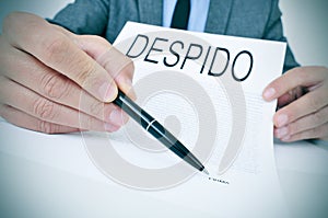 Man shows a document with the text despido, dismissal in spanish photo