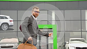 A man shows emotions of happiness after buying a new electric car near a car dealership