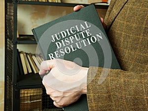 Man shows judicial dispute resolution JDR book.