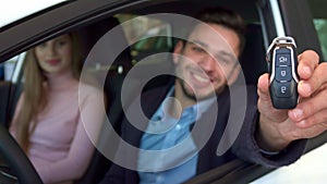 Man shows key through the car window