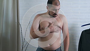 Man shows muscles. Touches the muscles on the chest