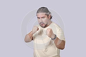 A man shows off his boxing moves with a defensive stance. Lighthearted scene of a man pretending to box