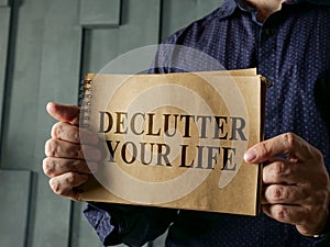 Man shows page with words declutter your life.