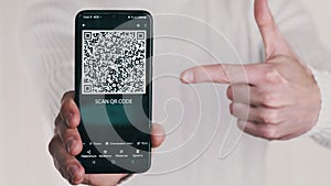 Man Shows QR Code on Smartphone and Shows Thumbs-Up Sign on White Background