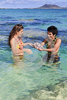 Man shows seashells to a young woman