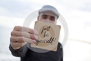 Man shows signboard with the text just be yourself