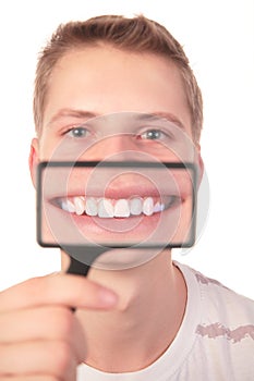 Man shows smile through magnifier