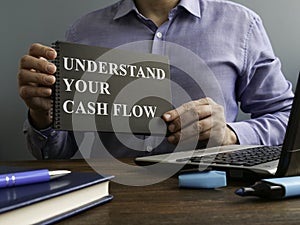 Man shows Understand your cash flow sign on page.