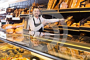 Man shows a variety of loaves of bread