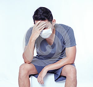 Man is sick and wear hygienic mask and headache.