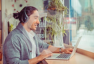 Man in side profile smiling having a online conversation, a video chat