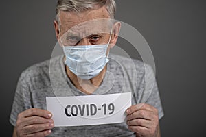 Man with a sign. Old man, 80 years old, in a medical protective mask.