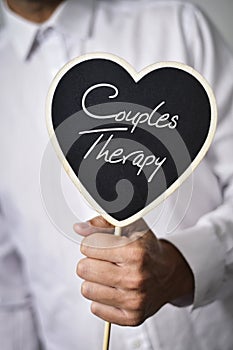 Man with signboard with text couples therapy photo