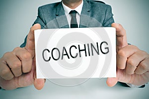 Man with a signboard with the word coaching photo