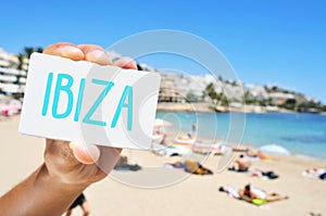 man with a signboard with the word Ibiza, in Ses Figueretes Beach in Ibiza Town, Spain photo
