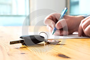 Man signing car insurance document or lease paper.