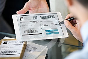 Man signing delivery receipt on digital tablet