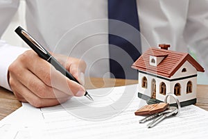 Man signing document at table in real estate