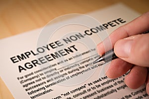 Man signing an employee Non-compete agreement photo