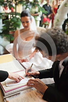 Man signing marriage papers