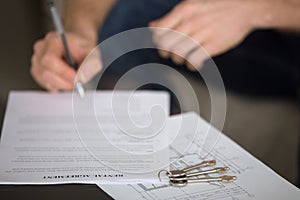 Man signing rental agreement, tenancy and rent concept, close up