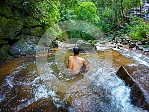 Man in silence in natural waterfall in green forests from different angle