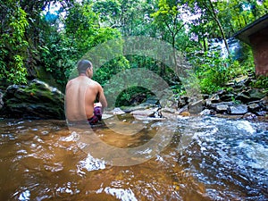 Man in silence in natural waterfall at green forests from different angle