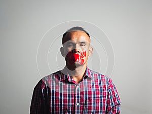 Man is silenced with adhesive red tape across his mouth sealed to prevent him from speaking. Freedom Concept