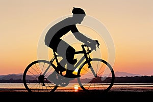 Man silhouette cycling at beach