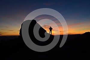 Man silhouette in mountains against sunrise background