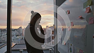 Man silhouette pondering whiteboard in sunset hall closeup. Developer working