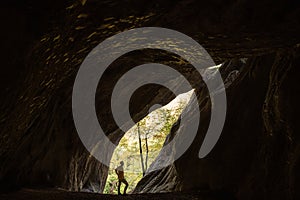 Man silhouette in rocky cave, sport photo