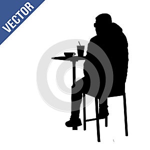 Man silhouette sitting at a table in the cafe, bar, restaurant or pub