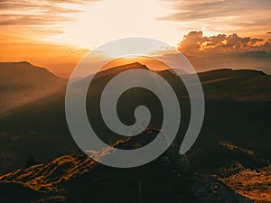 Man silhouette stay on a mountain top in dolomites during sunset