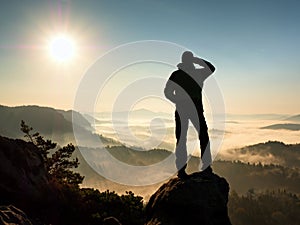 Man silhouette stay on sharp rock peak. Satisfy hiker enjoy view.