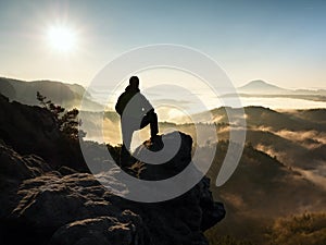 Man silhouette stay on sharp rock peak. Satisfy hiker enjoy view.