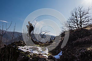 Man silhouette stay on sharp rock peak. Satisfy hiker enjoy view