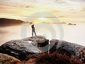 Man silhouette stay on sharp rock peak. Satisfy hiker enjoy view. Tall man on rocky cliff