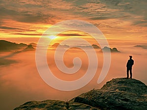 Man silhouette stay on sharp rock peak. Satisfy hiker enjoy view. Tall man on rocky cliff