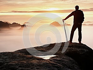 Man silhouette stay on sharp rock peak. Satisfy hiker enjoy view. Tall man on rocky cliff