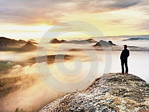 Man silhouette stay on sharp rock peak. Satisfy hiker enjoy view. Tall man on rocky cliff