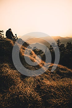 Man silhouette stay on sharp rock peak. Satisfy hiker enjoy view. Tall man on rocky cliff watching down to landscape