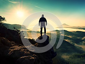 Man silhouette stay on sharp rock peak. Satisfy hiker enjoy view.