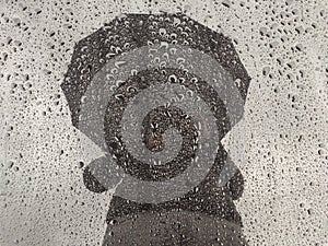 Man silhouette with umbrella under the rain.