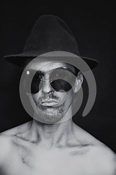 Man with silver make-up in hat and sunglasses