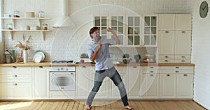 Man singing dancing barefoot on underfloor heated floor in kitchen