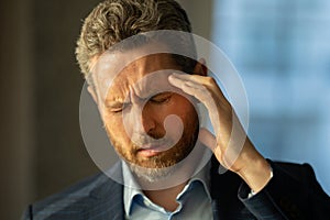 Man with sinus headache, tension or cluster headache, close up portrait. Head pain concept. Cephalalgia and migraine