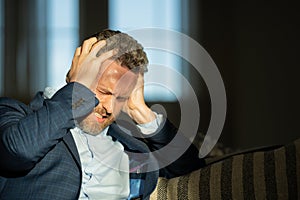 Man with sinus headache, tension or cluster headache, close up portrait. Head pain concept. Cephalalgia and migraine photo