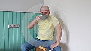Man Sipping Coffee in a Bright Kitchen During Morning